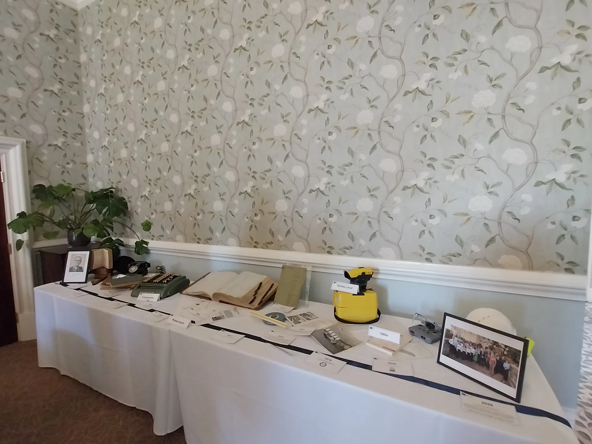 Long table set with vintage surveying items, books and photos